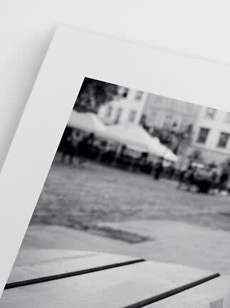 Nærbillede af sort-hvidt foto med hvid passepartout og sløret byscene