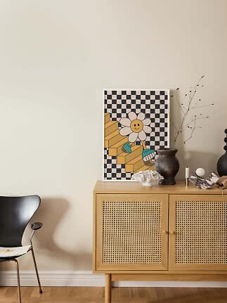 Poster med leende blomma mot rutig bakgrund, lutad på skänk med vas och dekorationer