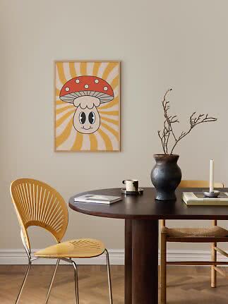 Framed poster of a cartoon mushroom on a yellow sunburst background above a round dining table