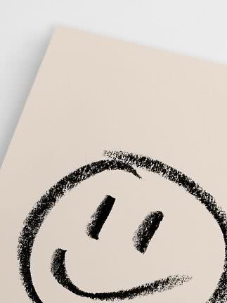 Primo piano di poster beige con smiley nero disegnato a mano su sfondo chiaro