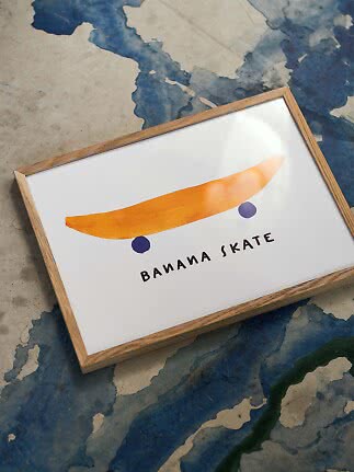 Framed poster with a banana shaped like a skateboard on a white background