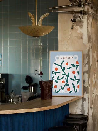 Gerahmtes Valencia-Poster mit Orangen auf Bartresen in rustikalem Café