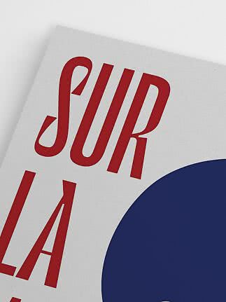 Close-up of poster with red lettering on a light background and a large dark blue circle