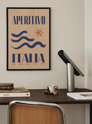 Framed Aperitivo Italia poster with blue waves and red sun above a desk