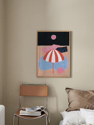 Framed abstract poster with parasol shapes and pink circles on a beige wall by a bed