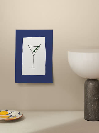 Blau gerahmtes Poster mit schlichter Martini-Glas-Zeichnung an beiger Wand