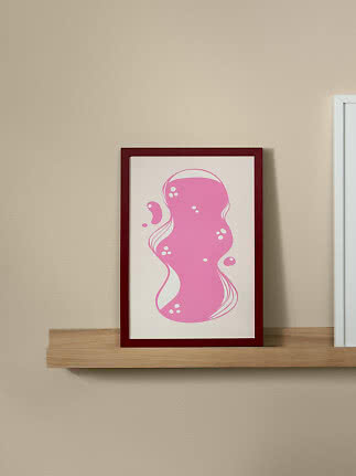 Affiche abstraite encadrée avec forme organique rose sur fond blanc, posée sur une étagère en bois