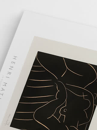 Nærbillede af indrammet kunstplakat med sort motiv af abstrakt, liggende figur på hvid baggrund