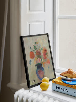 Affiche florale encadrée posée sur un rebord de fenêtre avec citrons, livres et croissant
