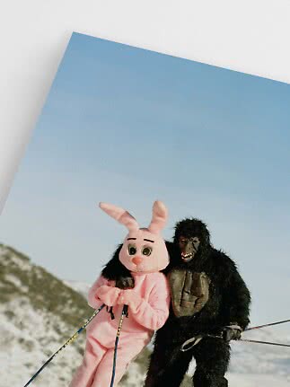 Persona in costume da coniglio rosa e persona in costume da gorilla sugli sci sulla neve