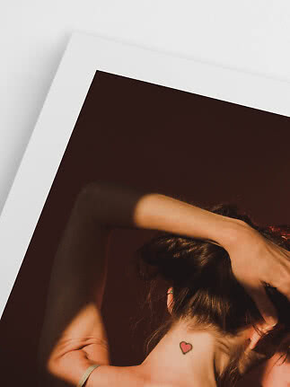 Close-up of woman's neck with small heart tattoo and hair tied up