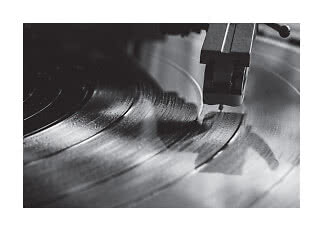 Primo piano della puntina di un giradischi su un vinile in rotazione, in bianco e nero