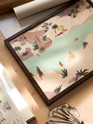 Framed illustration of a beach lagoon with swimmers, palm trees and a parasol on a table