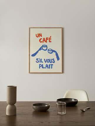 Indrammet plakat med teksten "Un café s'il vous plaît" og blå illustration af to kaffekopper.