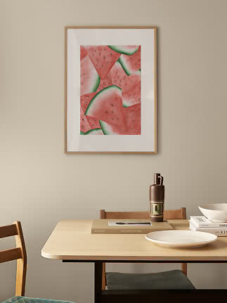 Affiche encadrée avec tranches de pastèque à l’aquarelle sur mur beige au-dessus d’une table