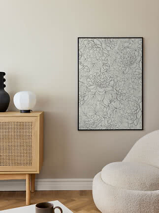 Sortindrammet blomsterplakat med fine linjetegninger på beige væg i stue