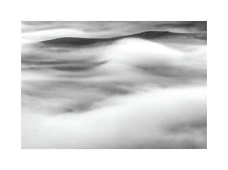 Paisaje en blanco y negro de picos montañosos entre nubes densas y niebla