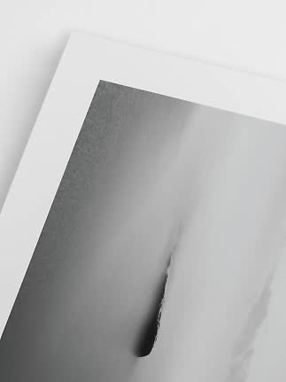Nærbillede af sort-hvid abstrakt plakat med hvid kant og bløde grå former