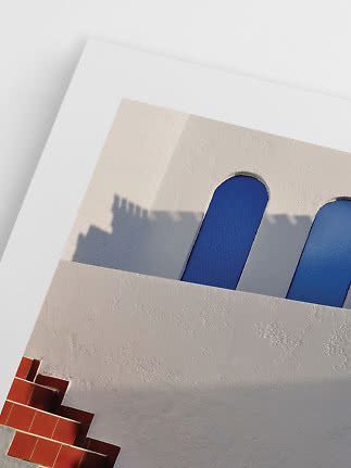 White stucco wall with blue arched windows and red tiled steps in sunlight
