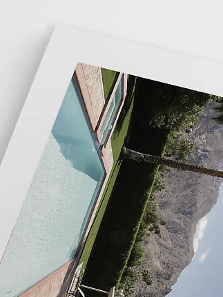 Indrammet foto af swimmingpool med palmer og bjerge i baggrunden