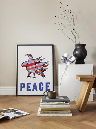 Gerahmtes Peace-Poster mit buntem Vogel, an eine Wand auf Holzboden gelehnt