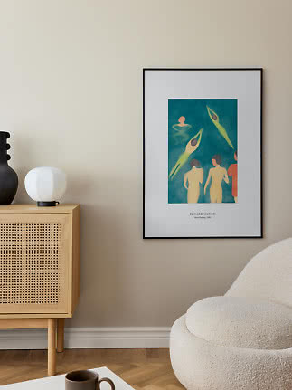 Framed Edvard Munch poster on a beige wall above a cabinet in a modern living room.