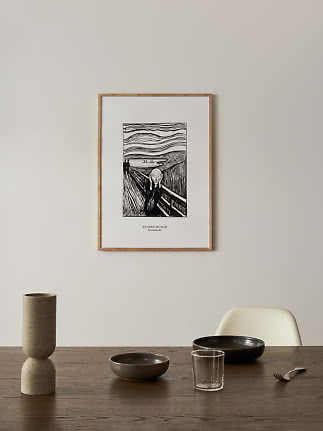 Poster incorniciato in bianco e nero de L’Urlo di Edvard Munch su parete chiara sopra il tavolo