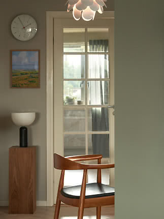 Comedor moderno con silla de madera, puerta de vidrio, lámpara colgante, reloj y lámpara