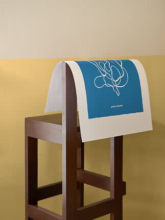 Blue and white art print with abstract line drawing draped over a dark wooden chair