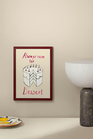 Indrammet plakat med tegnet lagkage og teksten "Always room for Dessert" på beige væg