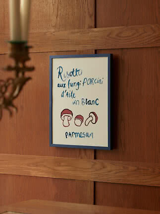 Framed handwritten food poster with mushroom illustration on a wooden wall