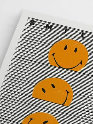Plakat med sorte striber, teksten "SMIL" og orange smiley-ansigter
