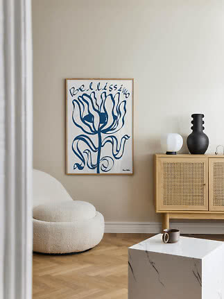 Blau-weißes Blumenposter im Holzrahmen über einem Schrank in einem hellen modernen Raum