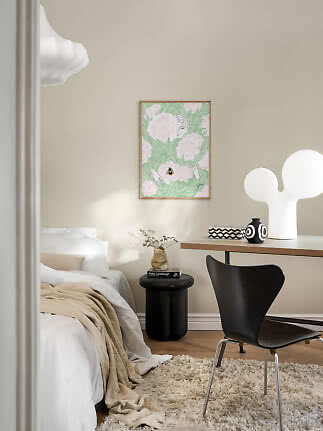Hyggeligt soveværelse med seng, skrivebord, sort stol og blomsterkunst på beige væg