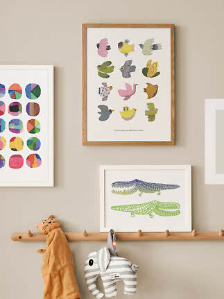 Children’s room with framed colorful bird poster above a coat rack with a soft elephant toy