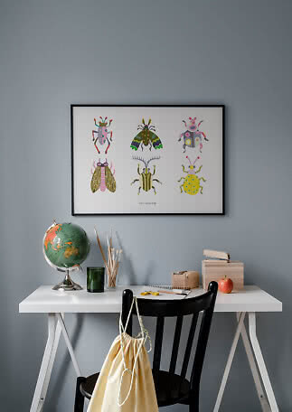 Framed poster with six colorful insects above a desk in a child's room