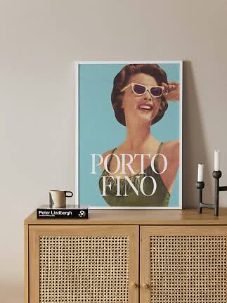 Framed Porto Fino poster with retro woman in sunglasses on a wooden cabinet