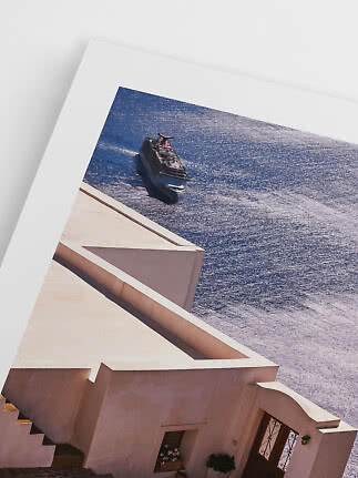 Framed photo of a cruise ship on shimmering blue sea above white buildings
