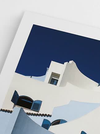 White building with curved lines and blue shutters against a deep blue sky