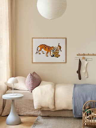 Barnrum med säng, kuddar, liten vit lampa och inramad Pippi-poster med en tiger