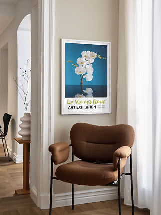 Indrammet plakat med hvide orkidéer på blå baggrund over en brun lænestol