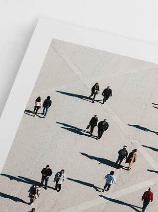 Overhead view of people walking across a light plaza with long shadows