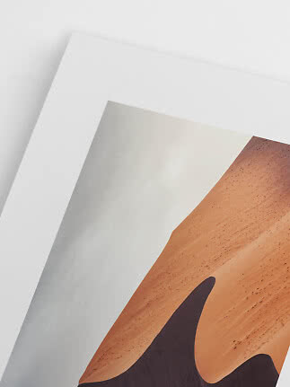 Nahaufnahme eines gerahmten Posters mit abstrakter Sanddüne in warmen Brauntönen