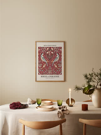 Poster Birds of Paradise incorniciato sopra tavolo apparecchiato con candela, bicchieri verdi e vaso