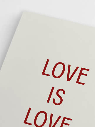 Close-up of a white poster with red text reading "LOVE IS LOVE"