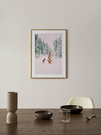 Gerahmter Winterdruck an der Wand über Esstisch mit Vase, Schalen und Glas