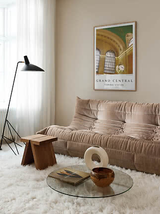 Wohnzimmer mit braunem Sofa, schwarzer Stehlampe und gerahmtem Grand-Central-Poster