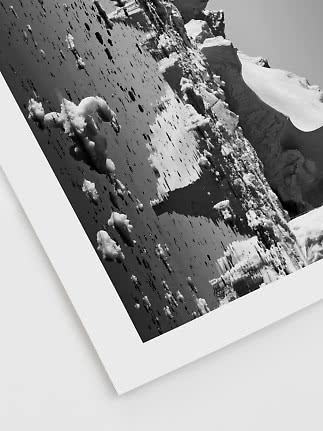 Schwarz-Weiß-Foto von Eis und Schnee auf dunklem Wasser am Rand eines Gletschers