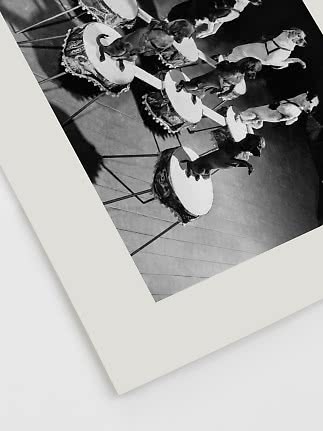 Zwart-witfoto van honden die balanceren op trommels tijdens een circusact