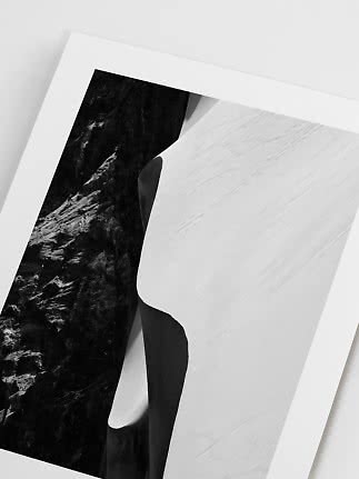 Black-and-white art print of a rock face and bright sand dune in a minimalist composition